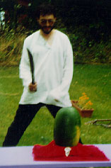 A guy with a machete, preparing to strike down a watermelon